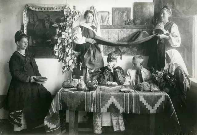 Cossack Mamai beside icons on the wall of a village house